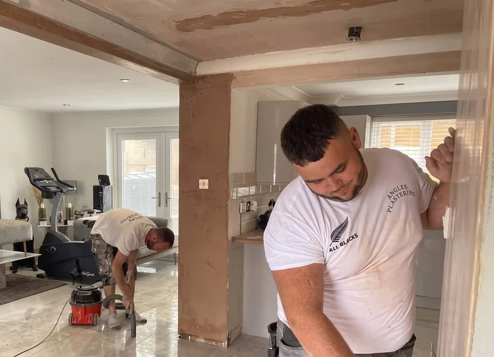APS Plastering team smoothing a freshly plastered wall